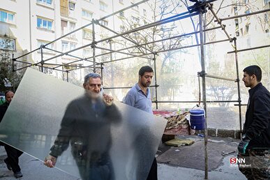 فعالیت گروه‌های جهادی برای نصب شیشه منازلی که در حملات دشمن آسیب دیده است + فیلم