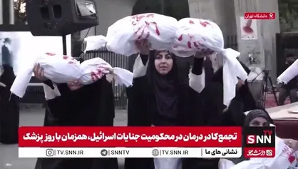 روی دست گرفتن نماد کودکان شهید جنایات رژیم صهیونیستی روی دستان کادر پزشکی تجمع کننده مقابل دانشگاه تهران