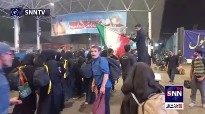 ادای احترام زائران حسینی به پرچم ایران هنگام بازگشت به وطن در مرز مهران