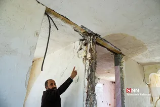 سی سخت، دوماه بعد از زلزله- صاحب خانه محل خمیدگی ستون های اصلی خانه در اثر زلزله را به عکاس نشان می دهد.