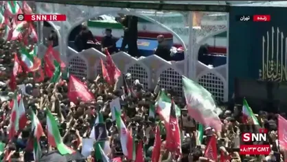 متبرک کردن پارچه و چفیه با تابوت پیکر رهبر شهید و خانواده ایشان