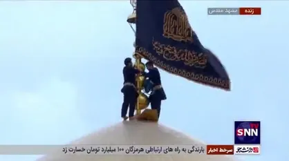 لحظه آویختن کتیبه&zwnj;های عزای سیدالشهدا (ع) در حرم مطهر رضوی (ع) همزمان با برافراشتن پرچم عزا بر گنبد مطهر