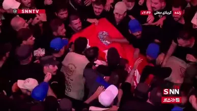 پوشانده شدن پیکر مطهر رهبر شهید با پرچم سرخ گنبد مطهر سیدالشهدا (ع)