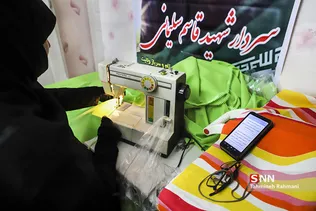 خانم کاظمی در حال دوخت مقنعه برای دختران کم بضاعت است.