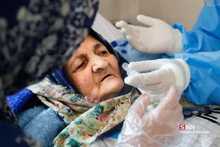 خانم شهبازی با استفاده از سرنگ به یکی از بیماران آب می دهد.