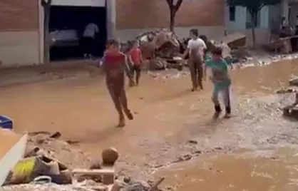 فوتبال بازی کردن چند کودک در منطقه&zwnj;ای از شهر والنسیا که پس از سیل ویران شده