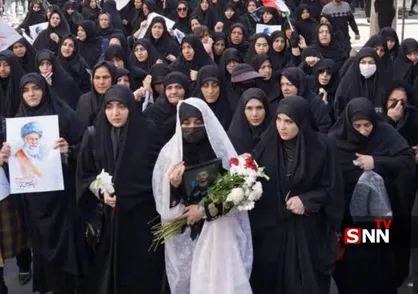 همسر شهید محمد نقوی با چادر سفید و گل به بدرقه همسرش آمد