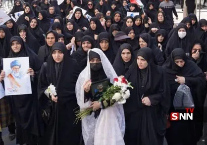 همسر شهید محمد نقوی با چادر سفید و گل به بدرقه همسرش آمد