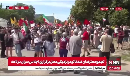 پرچم ایران در دستان معترضان ضد ناتو در نزدیکی محل برگزاری اجلاس سران در لاهه