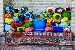 اعضای گروه جهادی به منظور تهیه عکس برای صفحات مجازی، کلاه های بافته شده را روی تاقچه مسجد صنیع و الدیوان چیدند.