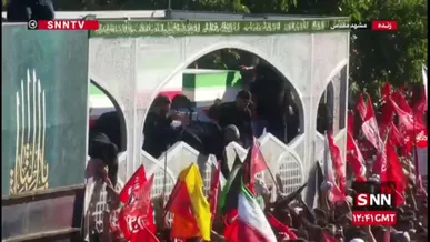 متبرک کردن پارچه و چفیه با تابوت پیکر رهبر شهید در مشهد